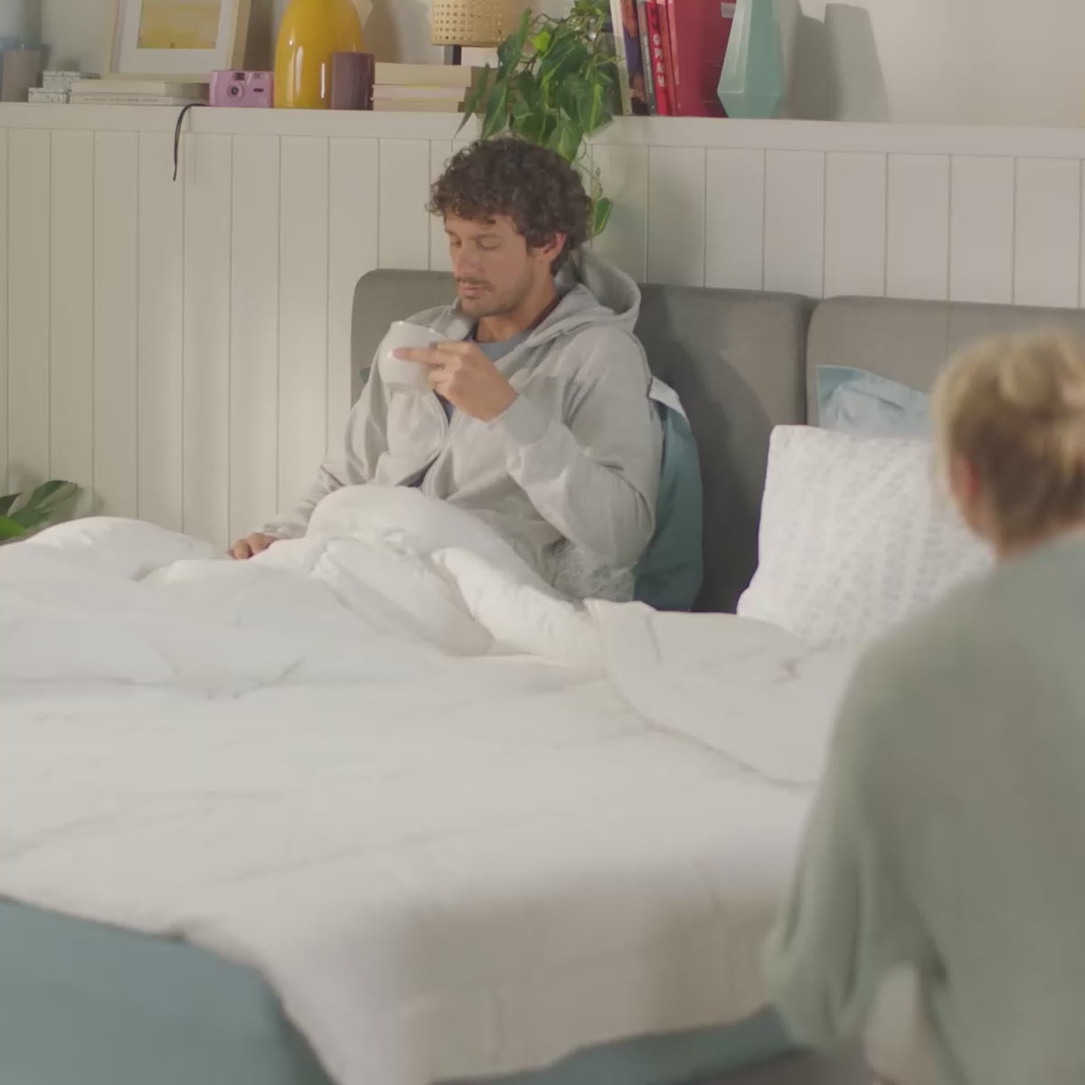 Homem e mulher na cama, exibindo o edredon branco